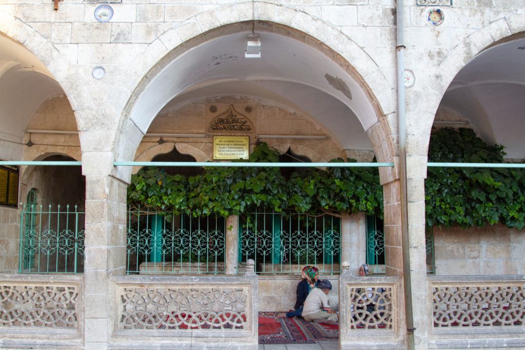 Women sitting in shade near Balikligol in Sanliurfa.