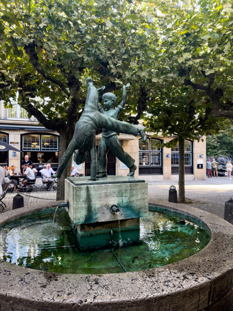 Cartwheel statue in a quaint square in Düsseldorf, perfect place to sit on a weekend trip.