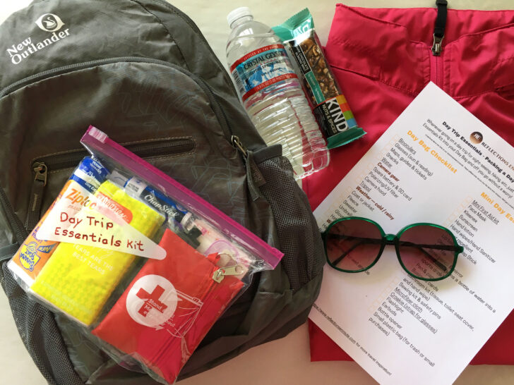 A day trip check list and a small day bag with items typically packed in a day bag.