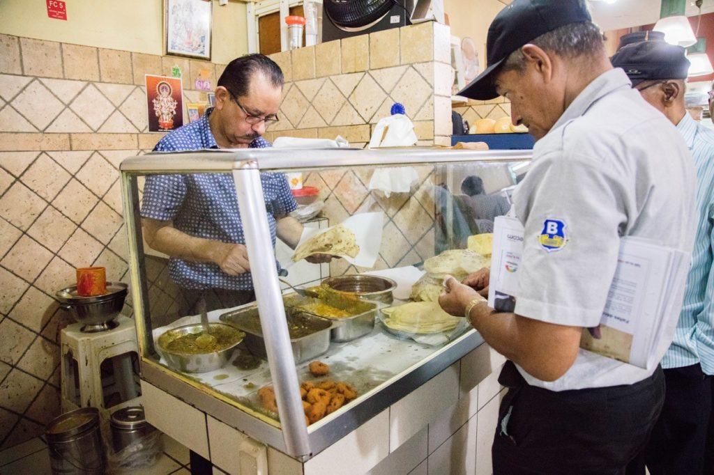 Dholl puri vendor making one for a worker in Port Louis Central Market.
