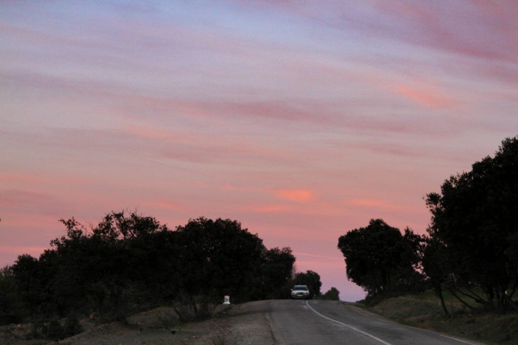 The sky is painted with red and orange streaks at sunset in the High Atlas Mountains in Morocco.