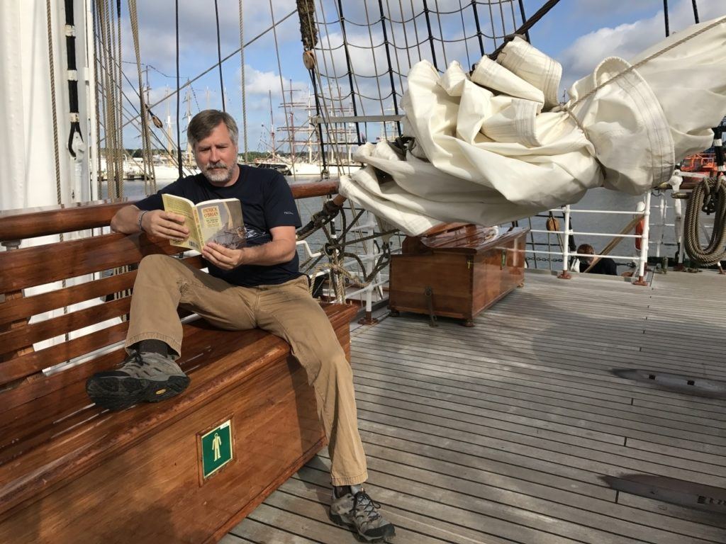 Jim reading a sailing book where I longed for a sailing adventure.