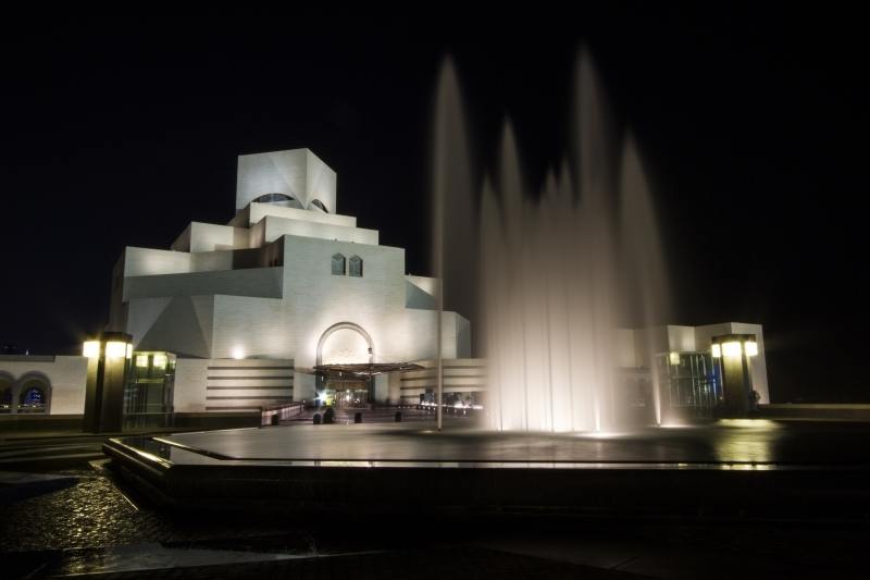 Museum Islamic Art Doha with fountains at night.