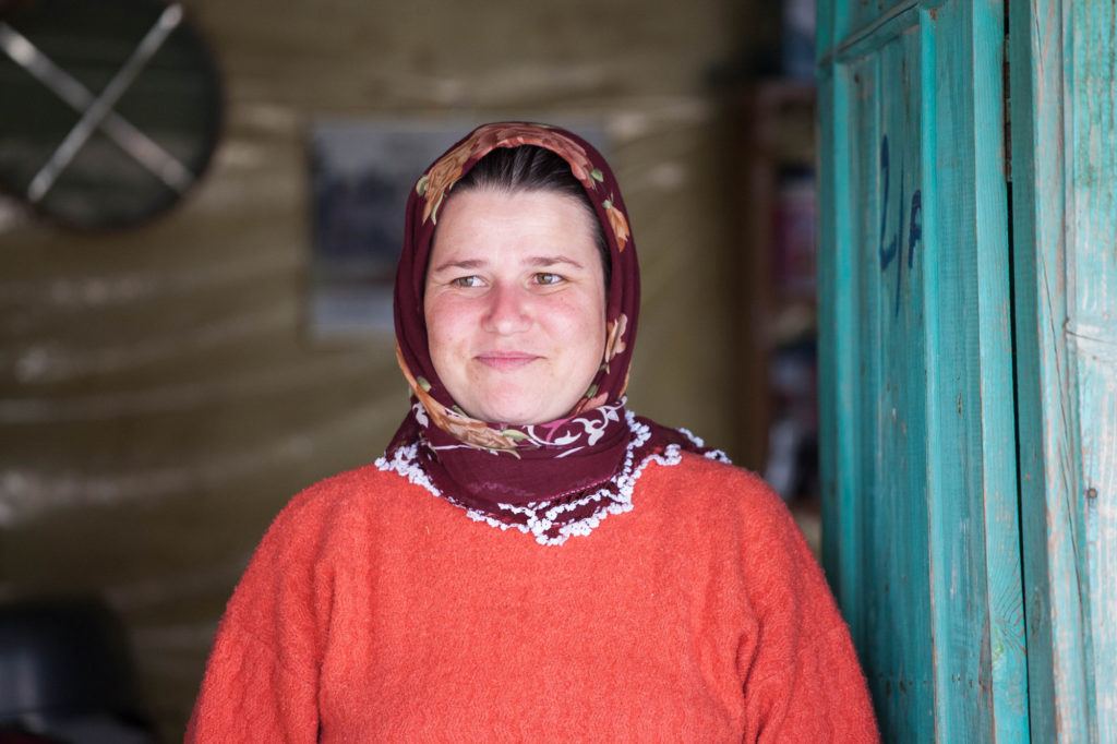 One of the village ladies standing in front of her blue door.