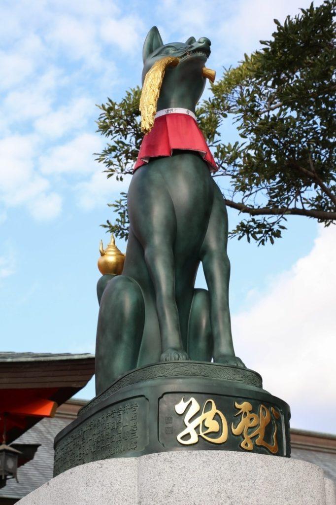 Closeup of guardian fox statue at Fushimi Inari shrine.