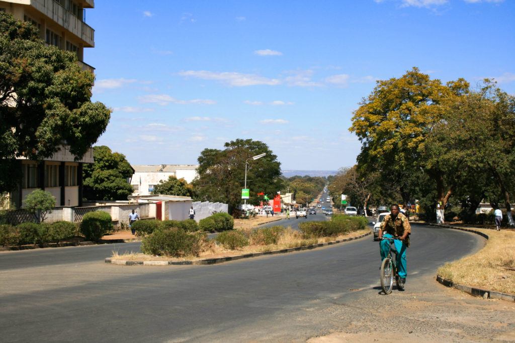 A man riding a bike on the streeet during the morning rush hour in Livingstone, Zambia.