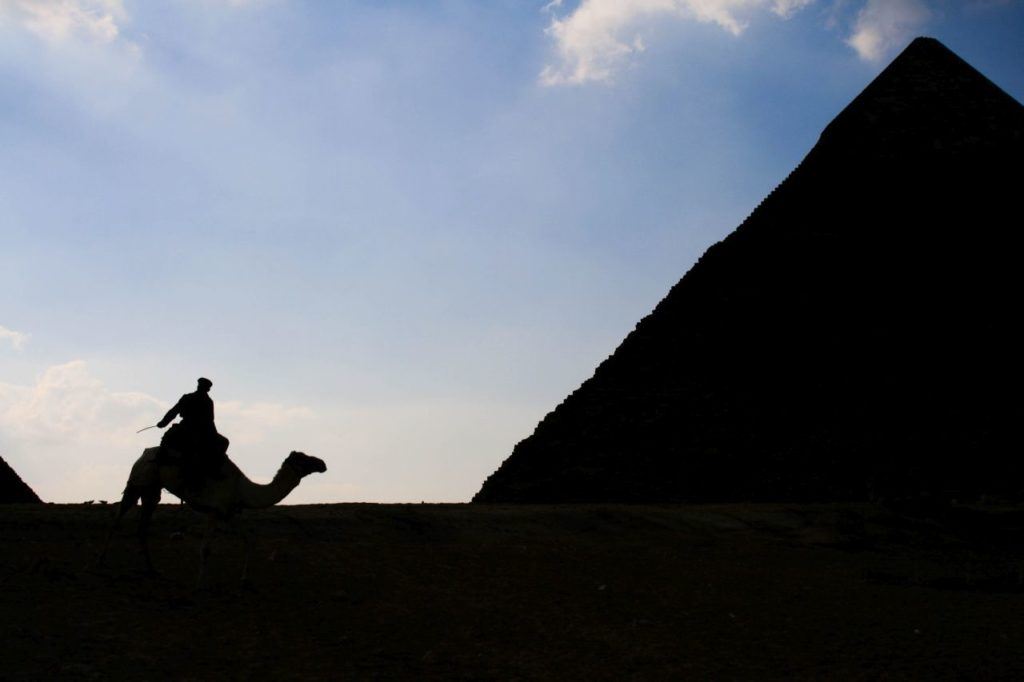 Silhouette of soldier and pyramid.