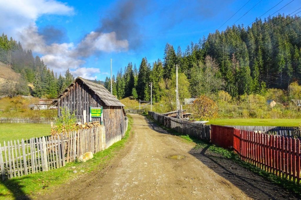 A dirt road and log cabin in Transylvania, Romania.
