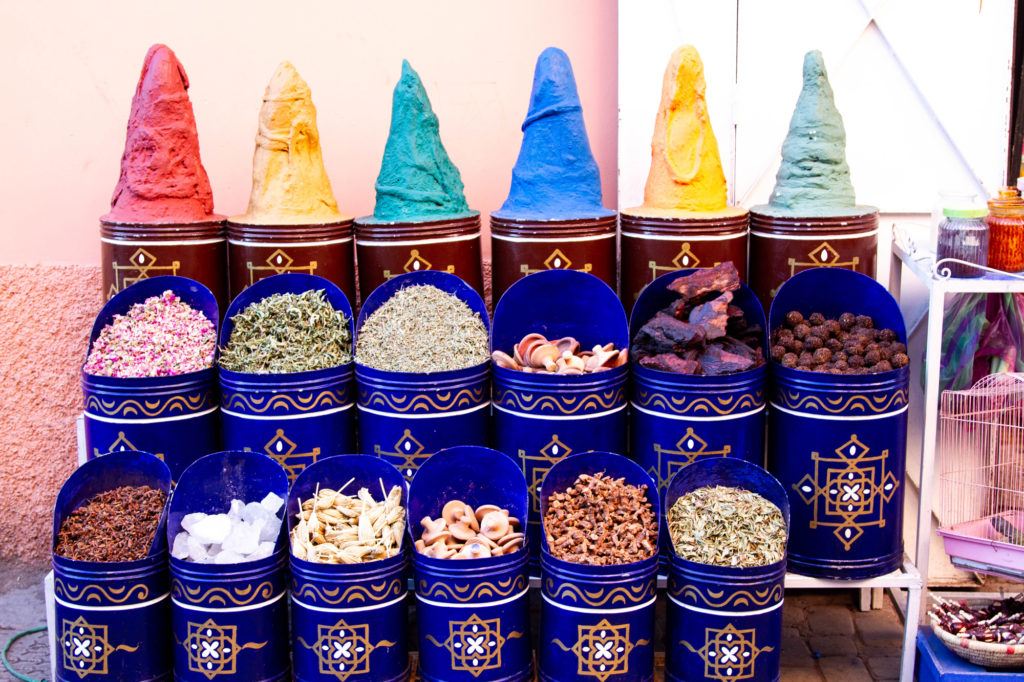 Spices and dried foods displayed in canisters in a Marrakech shop.