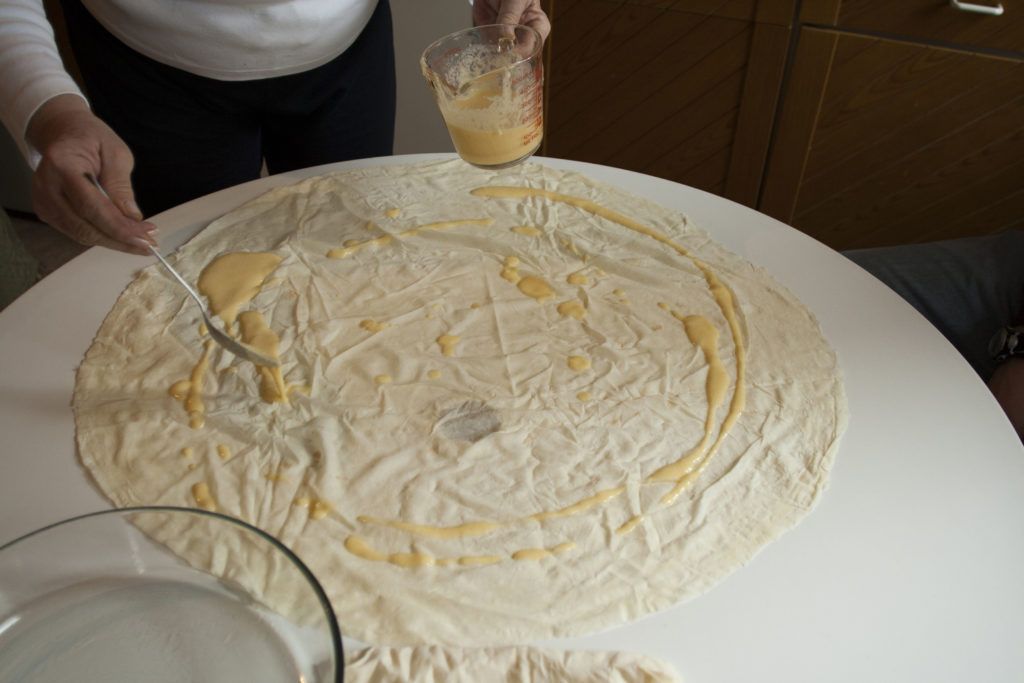 Fusun is preparing the yufka with egg wash before rolling it into a kol boregi.