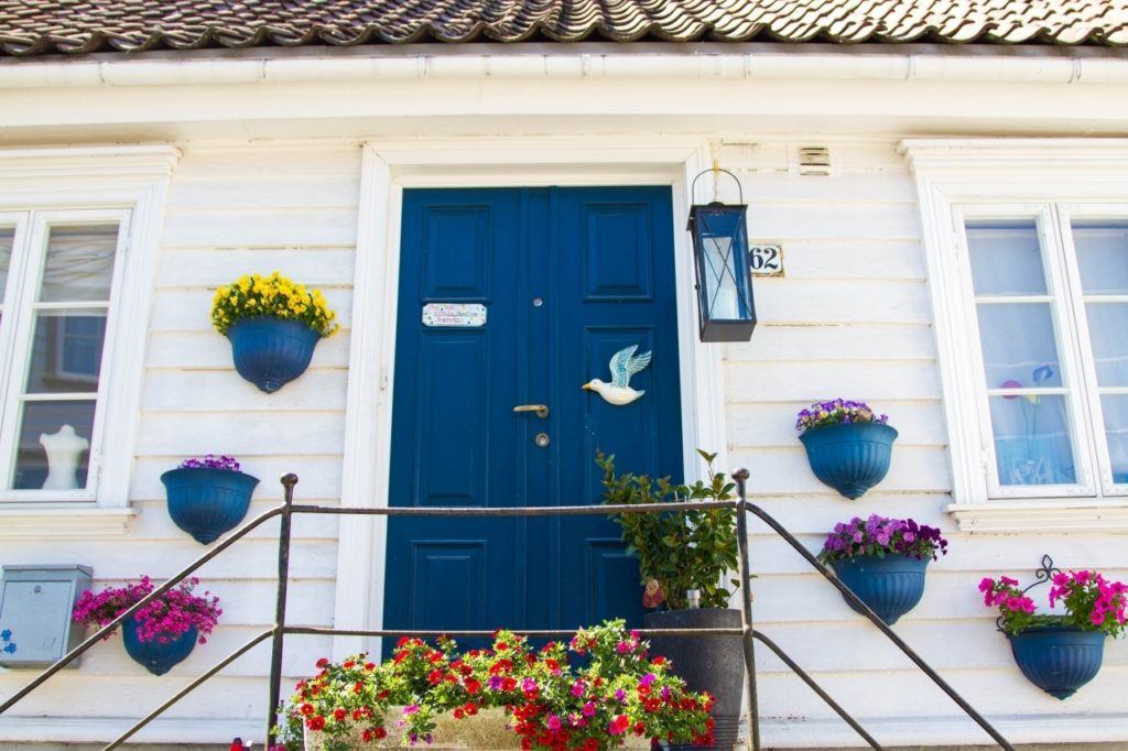 White house with blue door and blue flower pots in Gamle Stavanger.