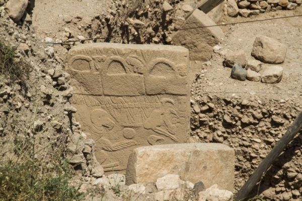 Large standing stone carved with strange animal reliefs.