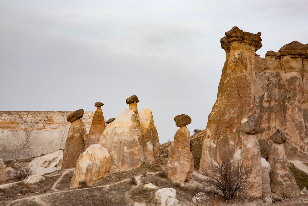 A cluster of fairy chimneys near Urgup, which form when rock pillars erode unevenly leaving a layer on top like a capstone.