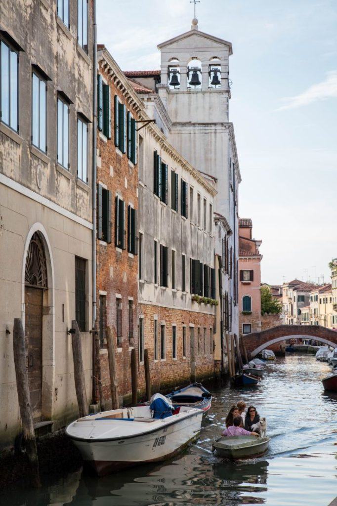 A small family out for a boat ride with their dog in Venice.