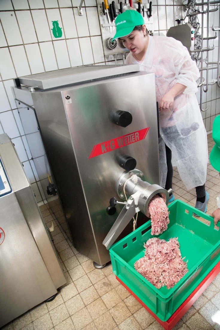 Devon running the pork grinder to make the bratwurst.