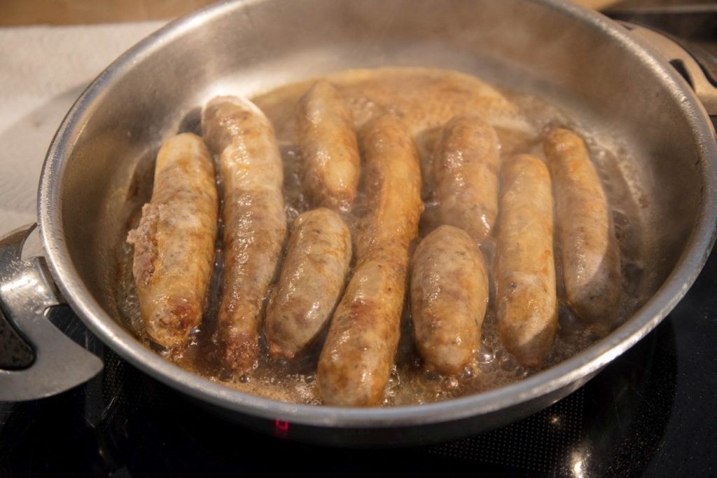 A pan of cooked homemade bratwurst after learning how to make wurst all day. 