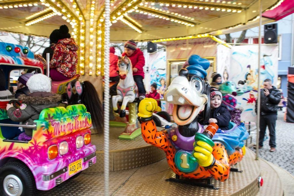 Taking the kids on the carnival rides at the Christmas market keeps them smiling.