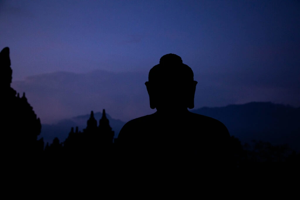 A Buddha statue in the morning, pre-sunrise light at Borobudur.