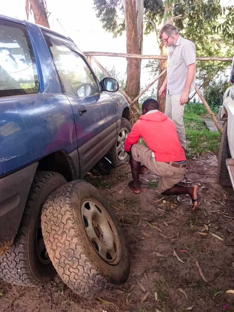 Changing a tire from the bad roads on our Uganda self drive.
