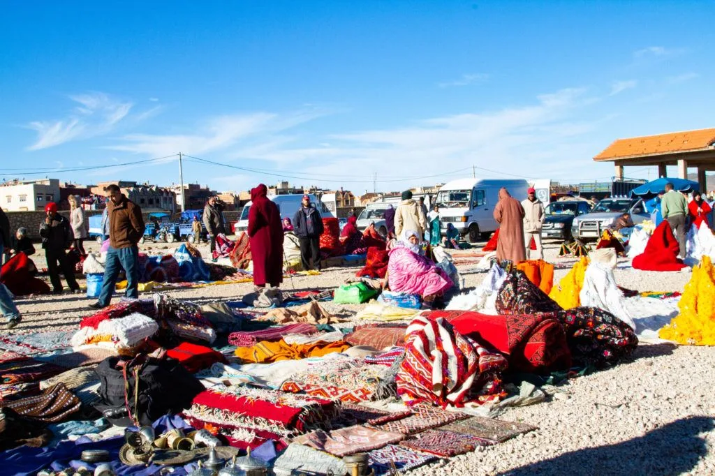 People shopping in a section of the Berber market dedicated to textiles, especially, handmade rugs and kilims.