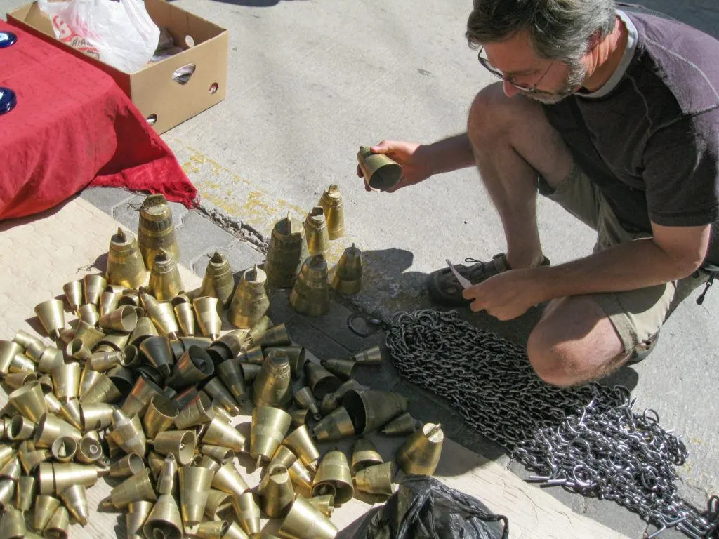 A man looks for just the right Turkish souvenir in a pile of livestock bells.