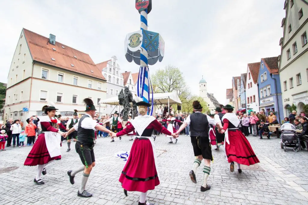 Townspeople dancing around the maypole on May 1st.