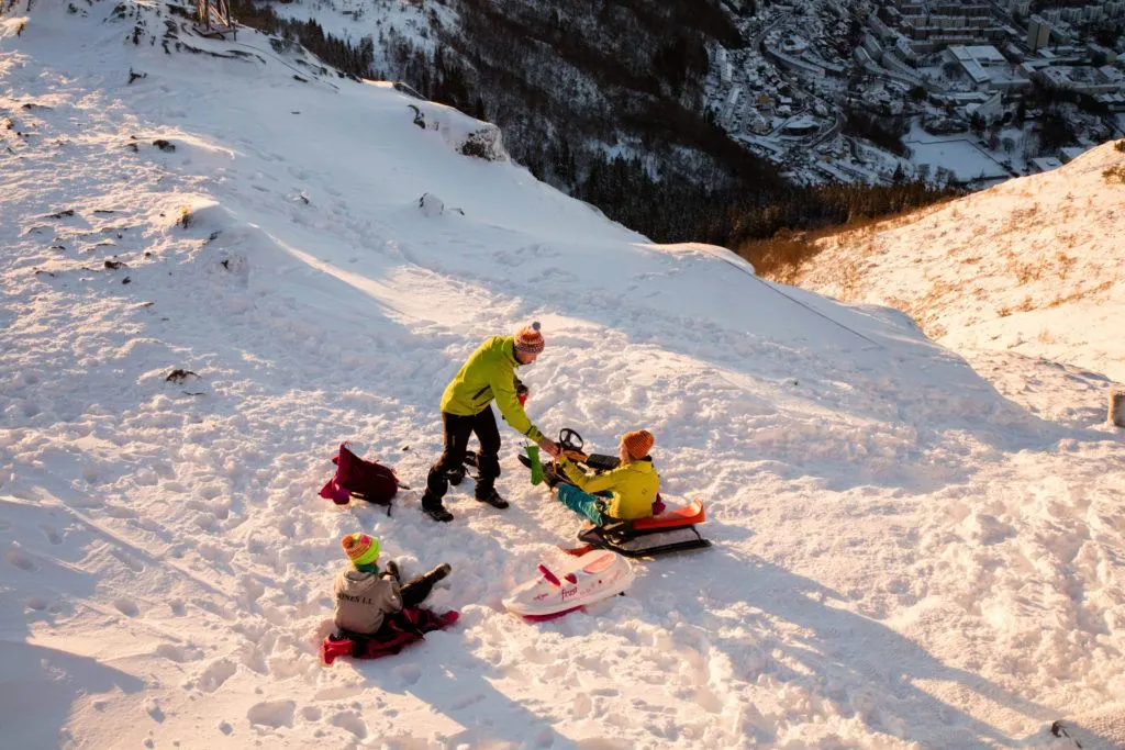 A family sledding in the afternoon light. It&rsquo;s a popular winter activity in Bergen.