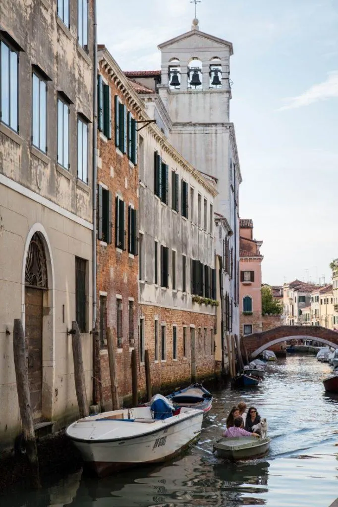 A small family out for a boat ride with their dog in Venice.
