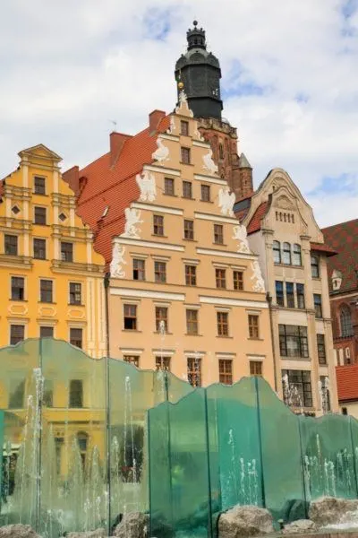 Zdroj Fountain found in Wroclaw's Market Square, with beautiful buildings in the background. Wroclaw is one of the prettiest cities in Europe.